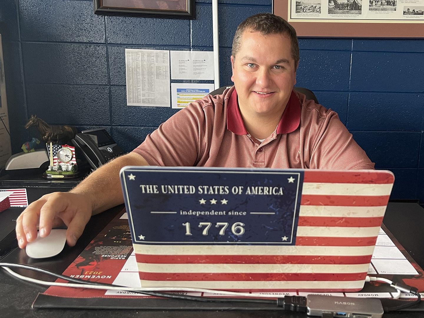 Mike Thomas, teacher at Sheridan High School, smiled from behind his patriotically decorated laptop.